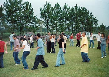 Mexican-Americans dancing together in a loose circle.