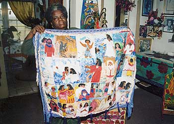 A woman holds a quilt